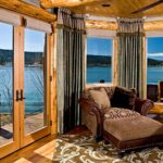 Wood-framed doors and windows framing a lake view from a living room