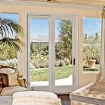 White vinyl patio doors opening to a garden from a sitting area