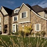 Stone and shingle home exterior with white vinyl replacement windows