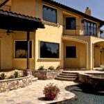 Tan Mediterranean-style home with fiberglass windows at dusk