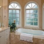 Arched fiberglass window above a soaking tub in a luxury bathroom