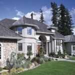 Two-story stone and stucco home with arched fiberglass windows