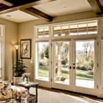 Fiberglass French doors and transom windows opening to a backyard lawn