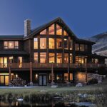 Timber and shingle lakeside home at dusk with fiberglass windows