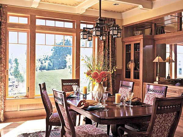 Wood-clad windows in a dining room overlooking the yard