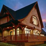 Craftsman shingle home at dusk with glowing wood-clad windows